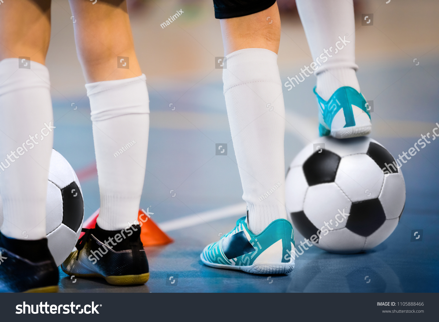 Indoor soccer players training with balls. Indoor soccer sports hall. Football futsal player, ball, futsal floor. Sports background. Futsal league. Indoor football players with classic soccer ball. #1105888466