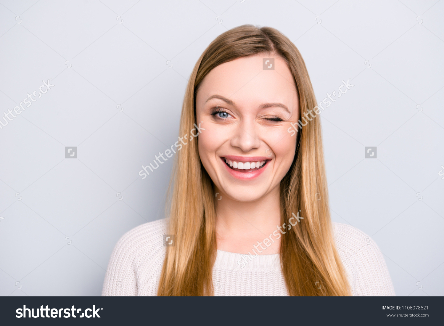 Head shot portrait of charming pretty laughter lovely girl in good mood winking with one eye isolated on grey background #1106078621