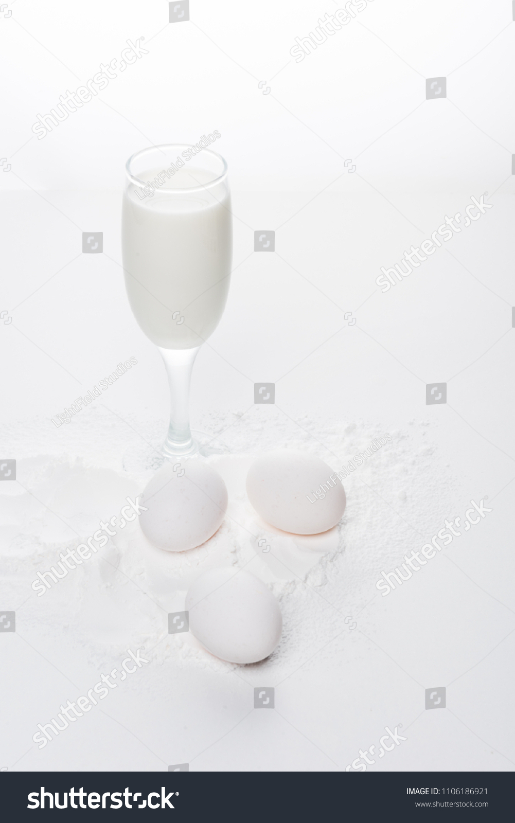 chicken eggs with flour and milk on white surface #1106186921