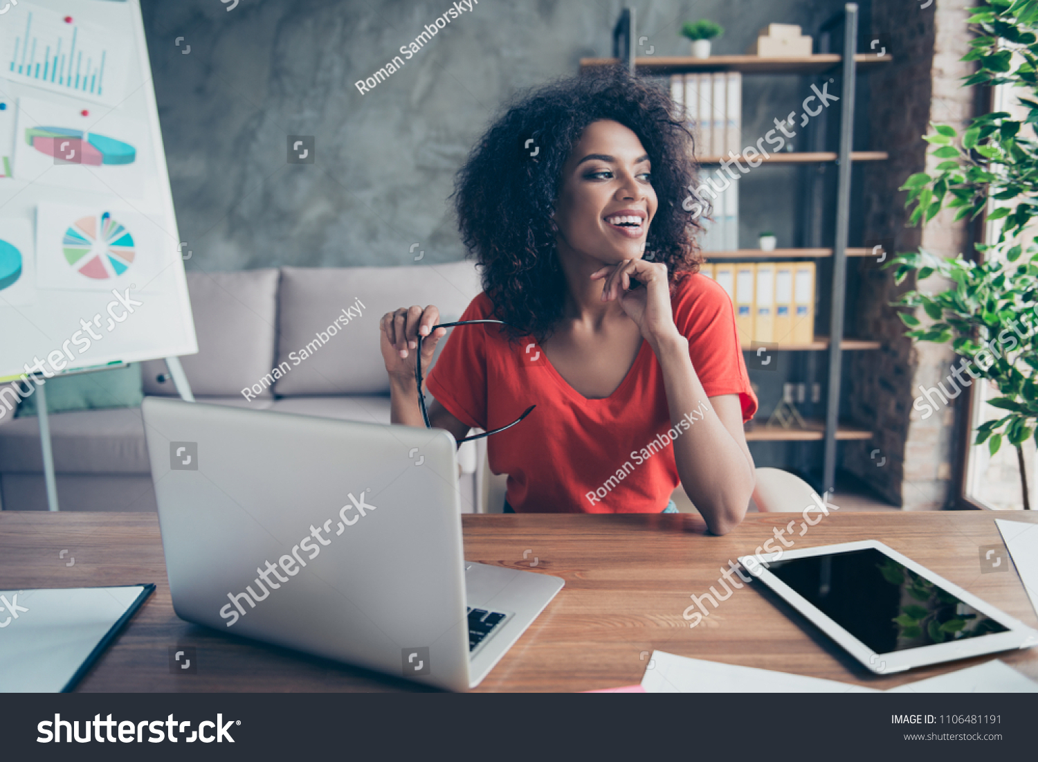 Portrait of pretty cheerful accountant looking away sitting at desk in modern office dreaming about weekend vacation enjoying view from window. Positive thinking person concept #1106481191