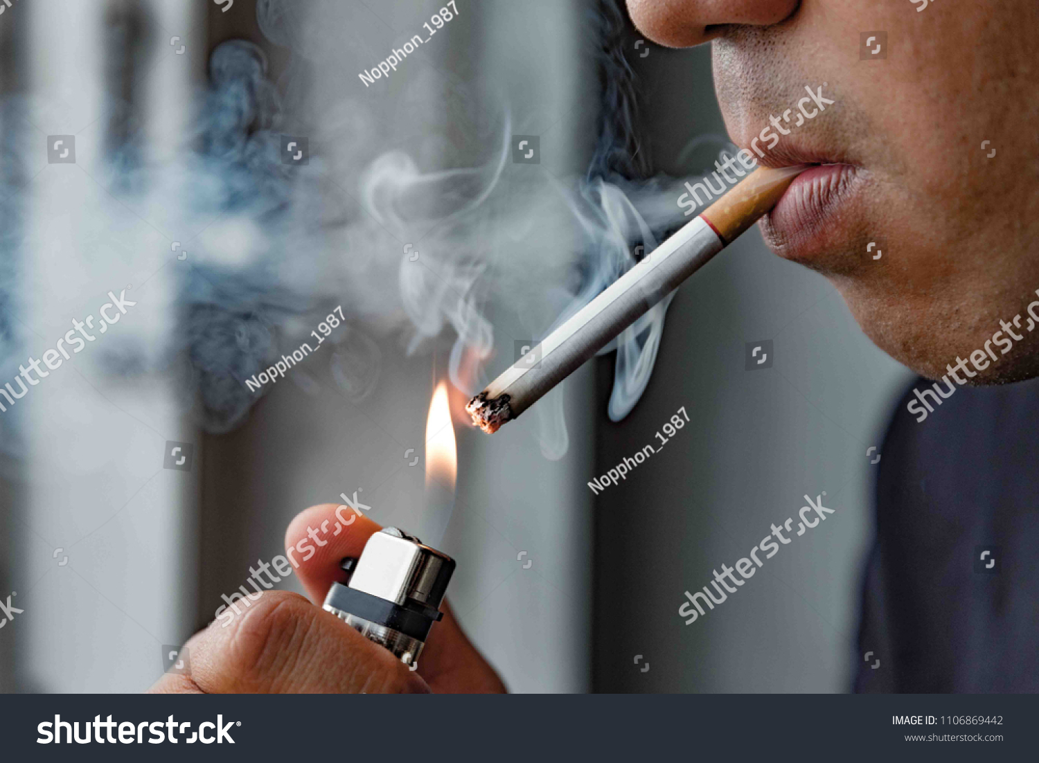 Close up young man smoking a cigarette. #1106869442
