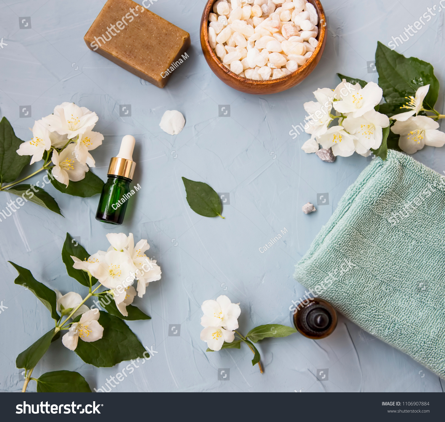 Spa setting flatlay with bath salt, jasmine oil bottle and flowers, towel and natural soap. Spa and wellness still life #1106907884