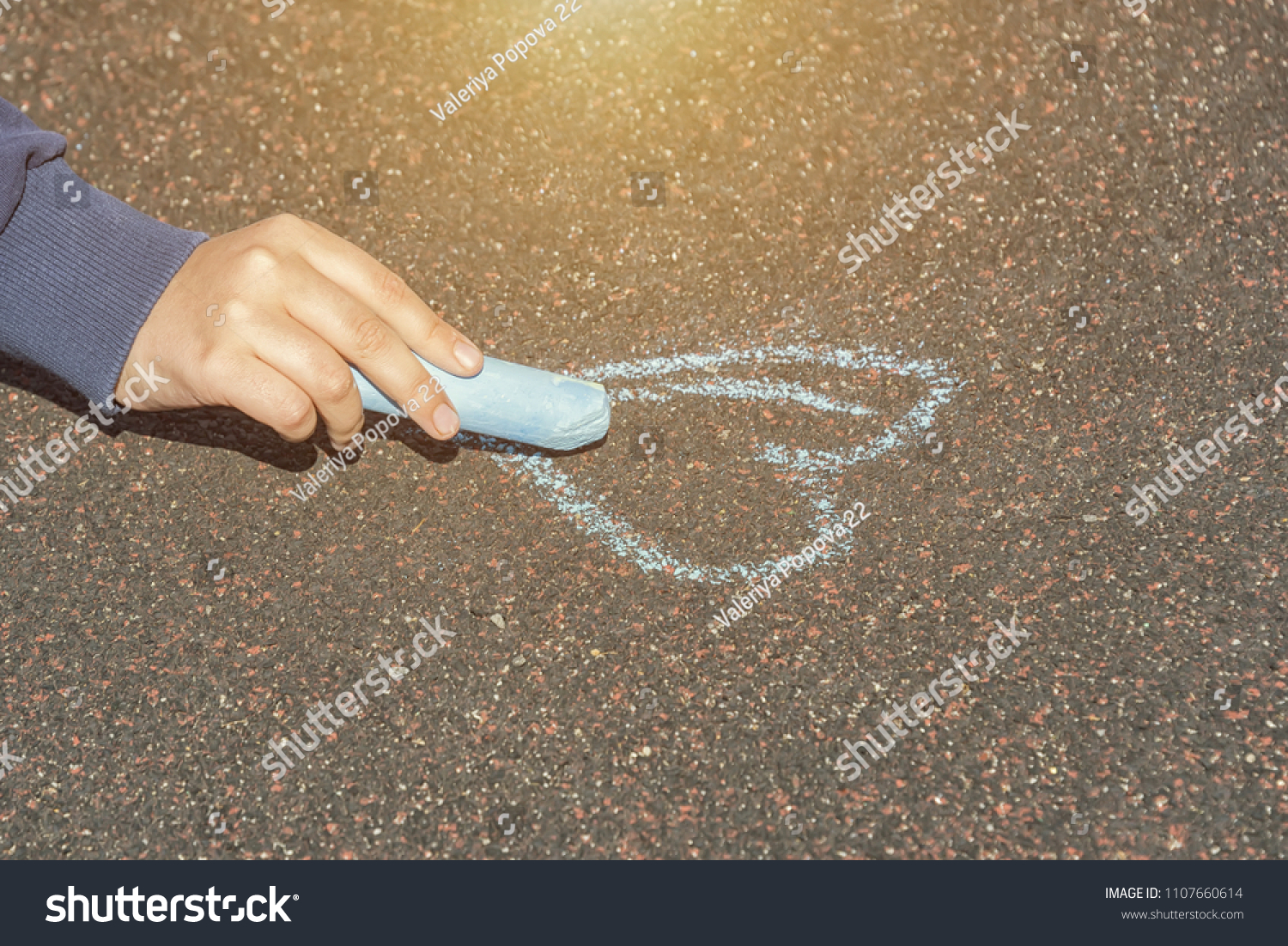 child's hand draws hearts, drawings chalk on asphalt #1107660614