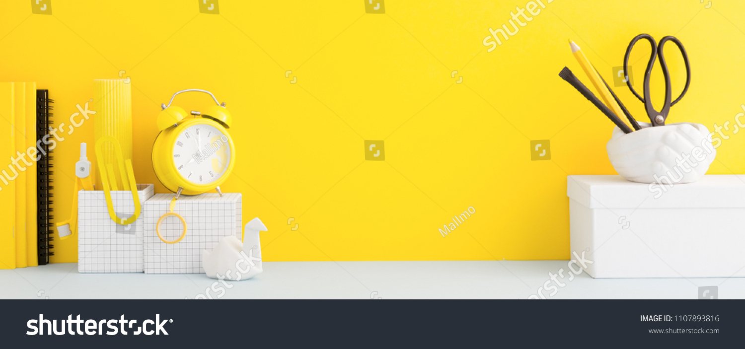 Desk and school supplies over the yellow pastel background. Education, studing and back to school concept Creative desk with yellow wall and stationery. #1107893816
