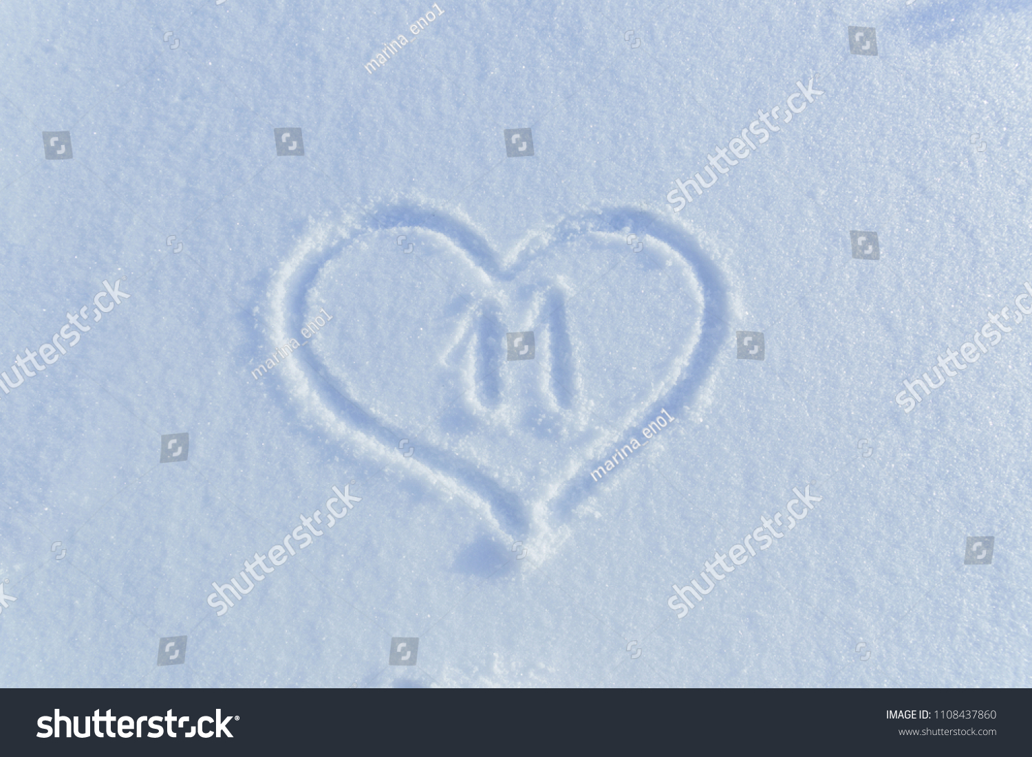 The number eleven
 drawn on the snow surrounded by a frame in the form of a heart. #1108437860