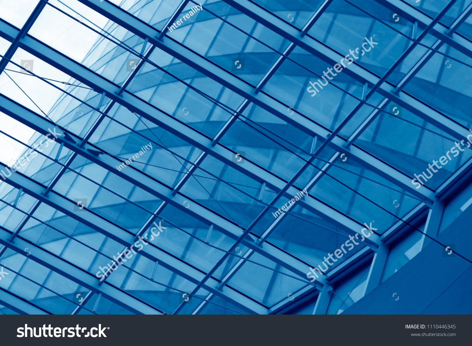 Business city with reflection of sky. Close-up of an office building visible through transparent framed walls. Modern architecture background with structural glazing / windows. #1110446345