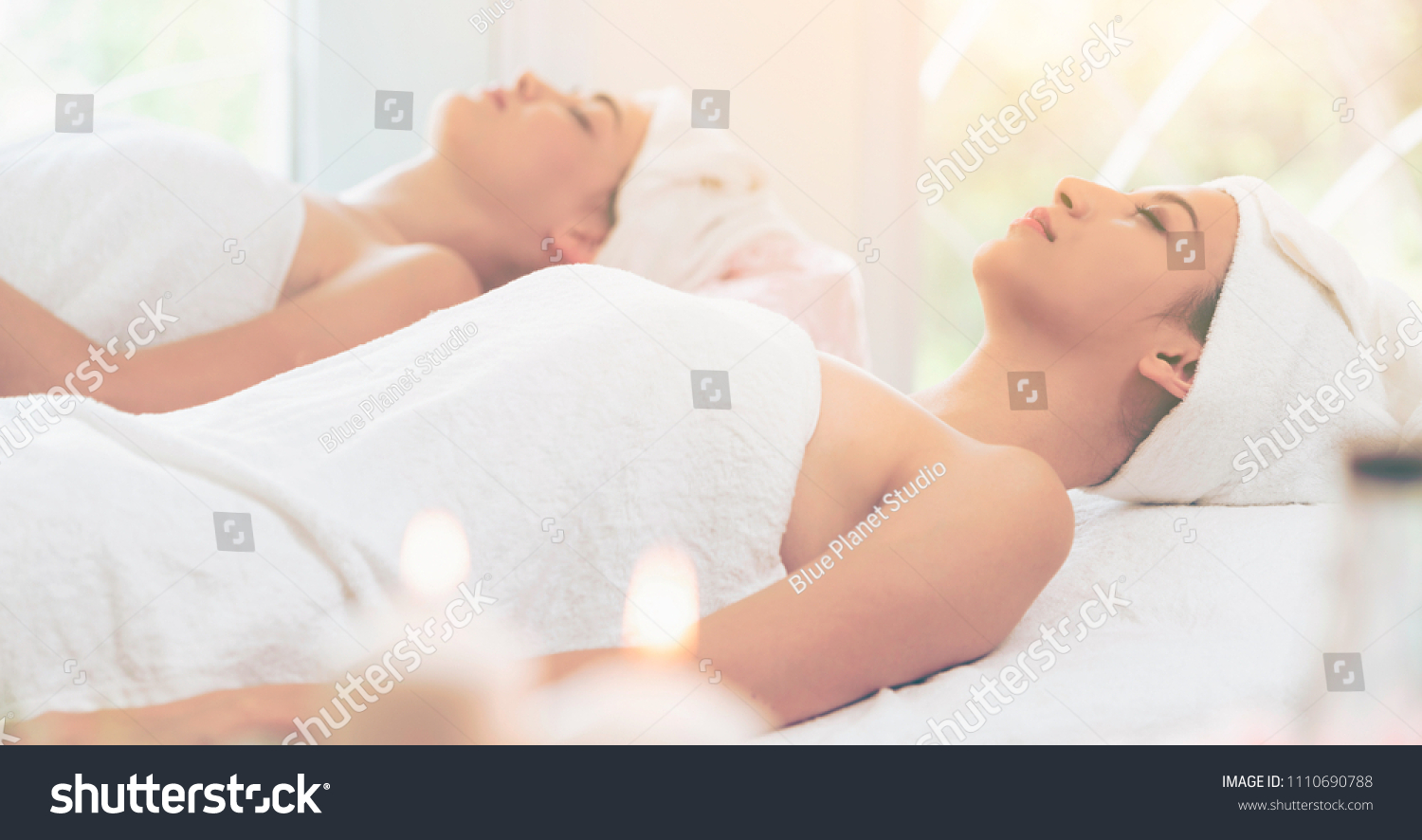 Relaxed young woman lying on spa bed prepared for facial treatment and massage in luxury spa resort. Wellness, stress relief and rejuvenation concept. #1110690788