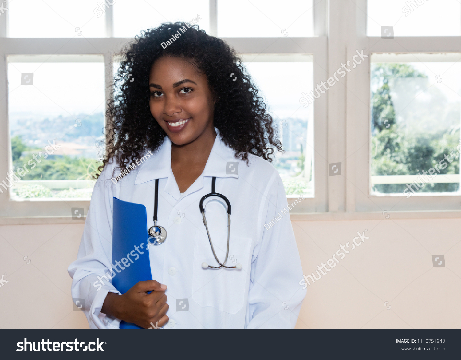 Laughing latin american nurse with file of patient indoors at hospital #1110751940