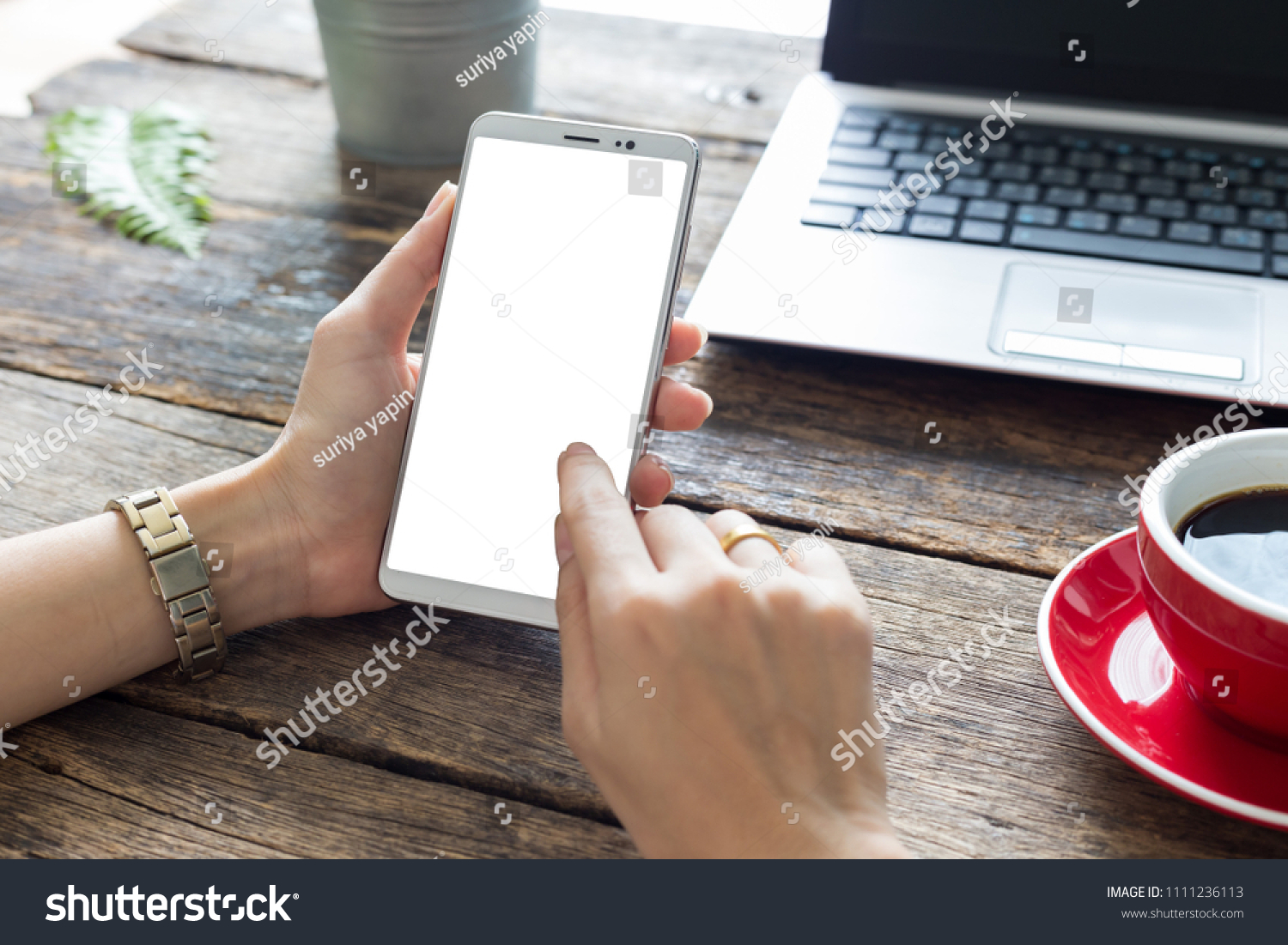 hand woman using a telephone, empty screen smart phone and computer on wooden table top view. with clipping path #1111236113