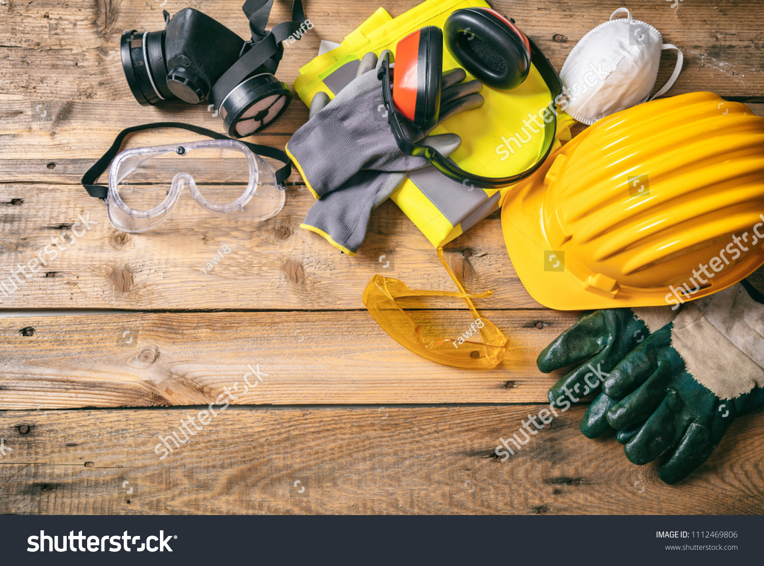 Work safety. Construction site protective equipment on wooden background, flat lay, copy space, top view #1112469806