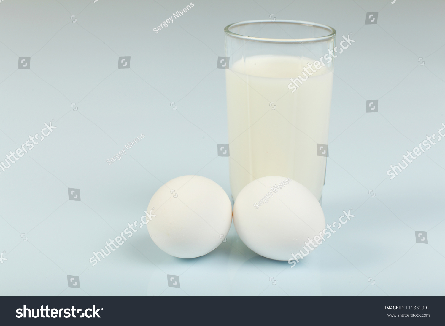 Milk in a glass jar and eggs on the table #111330992