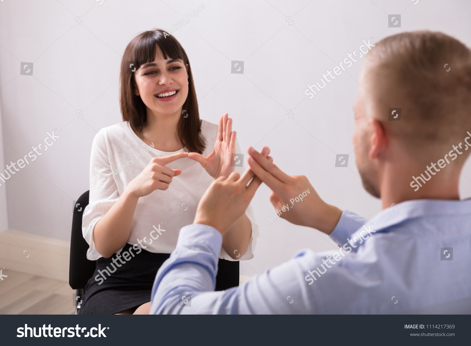 Smiling Young Woman And Man Talking With Sign Language On White Background #1114217369