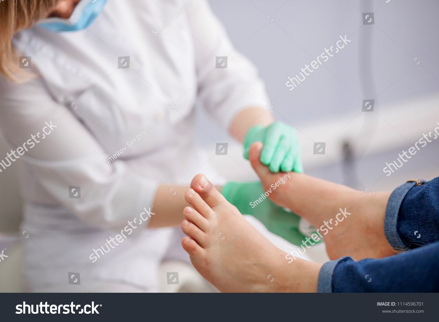 doctor, the podiatrist examines the foot #1114596701