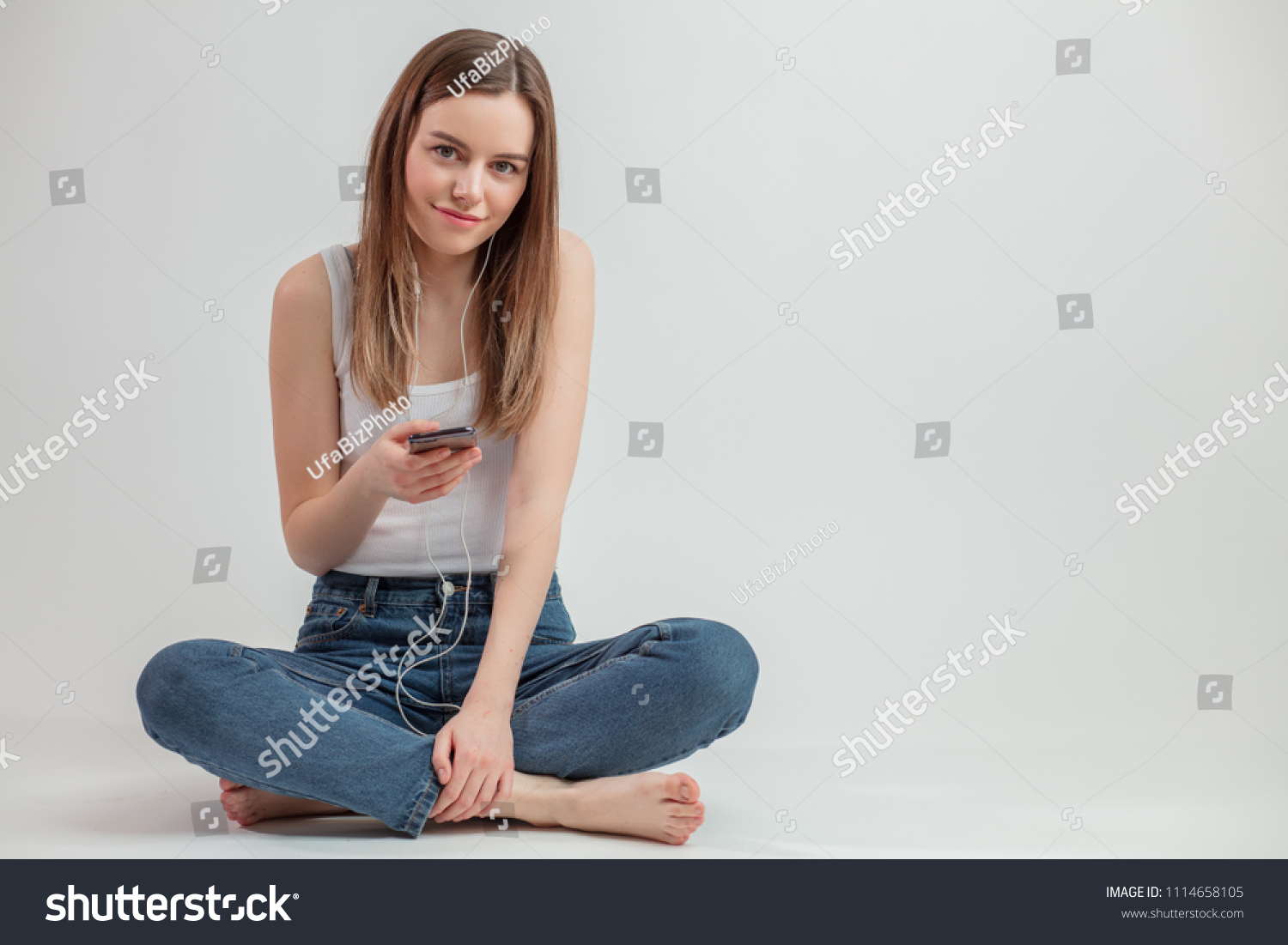 fair-haired cool girl holding mobile phone isolated on the white background. copy space. free time #1114658105