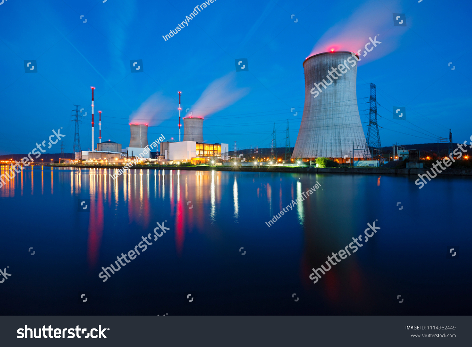 Night shot of a nuclear power plant close at a river with blue night sky. #1114962449