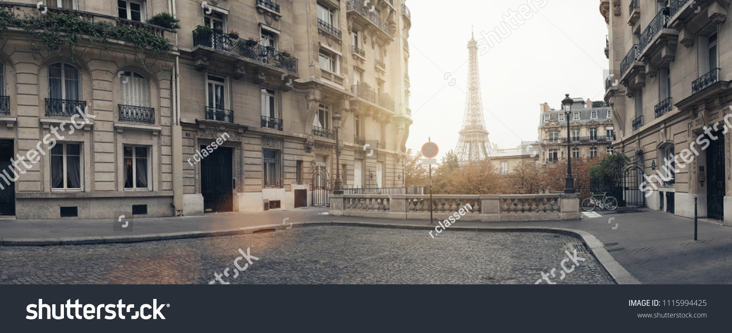 small paris street with view on the famous eiffel tower on a cloudy rainy day with some sunshine #1115994425