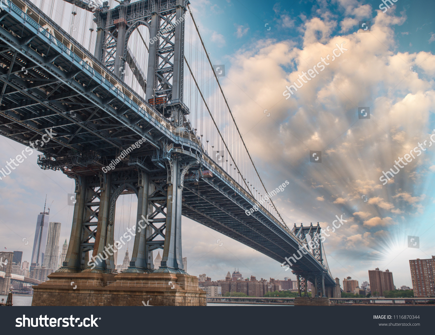 Powerful metallic structure of Manhattan bridge against a beautiful blue sky. #1116870344