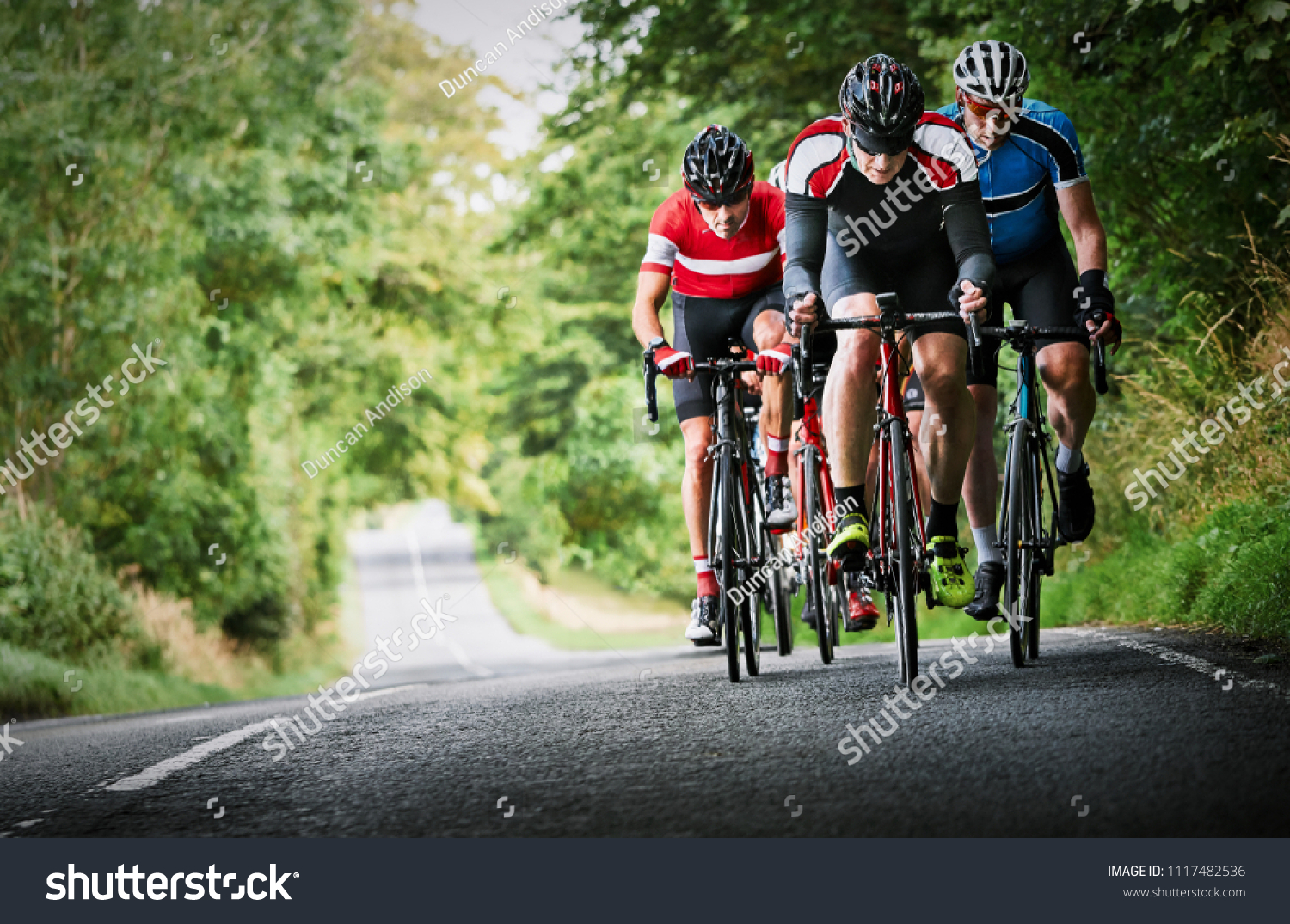 Cyclists racing on country roads on a sunny day in the UK. #1117482536