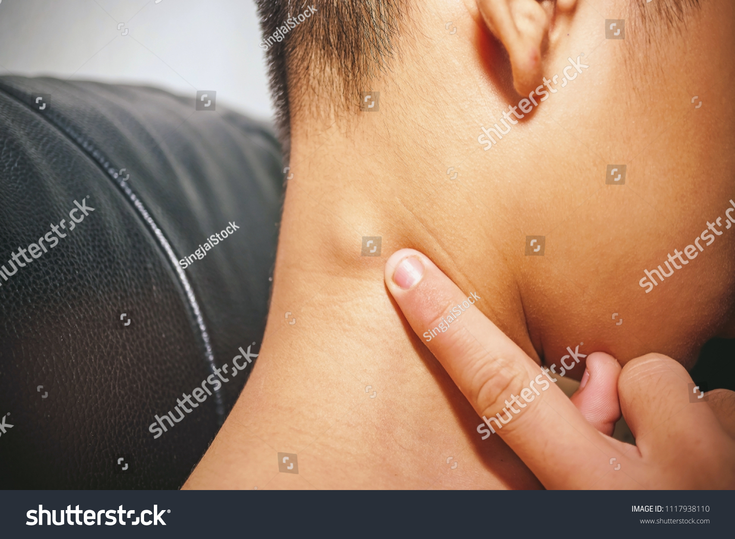 Lymph Node Swollen,  Closeup view of a young man with Sore throat or pain on the neck or thyroid gland he has inflammation lymph nodes in the neck, People body problem concept. #1117938110
