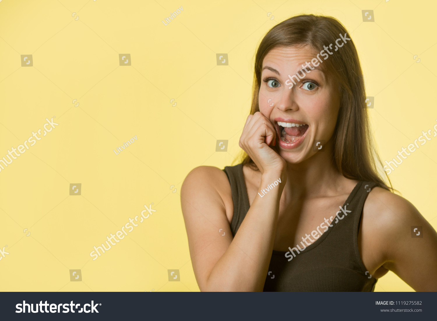 beautiful young girl with her hair on yellow background #1119275582