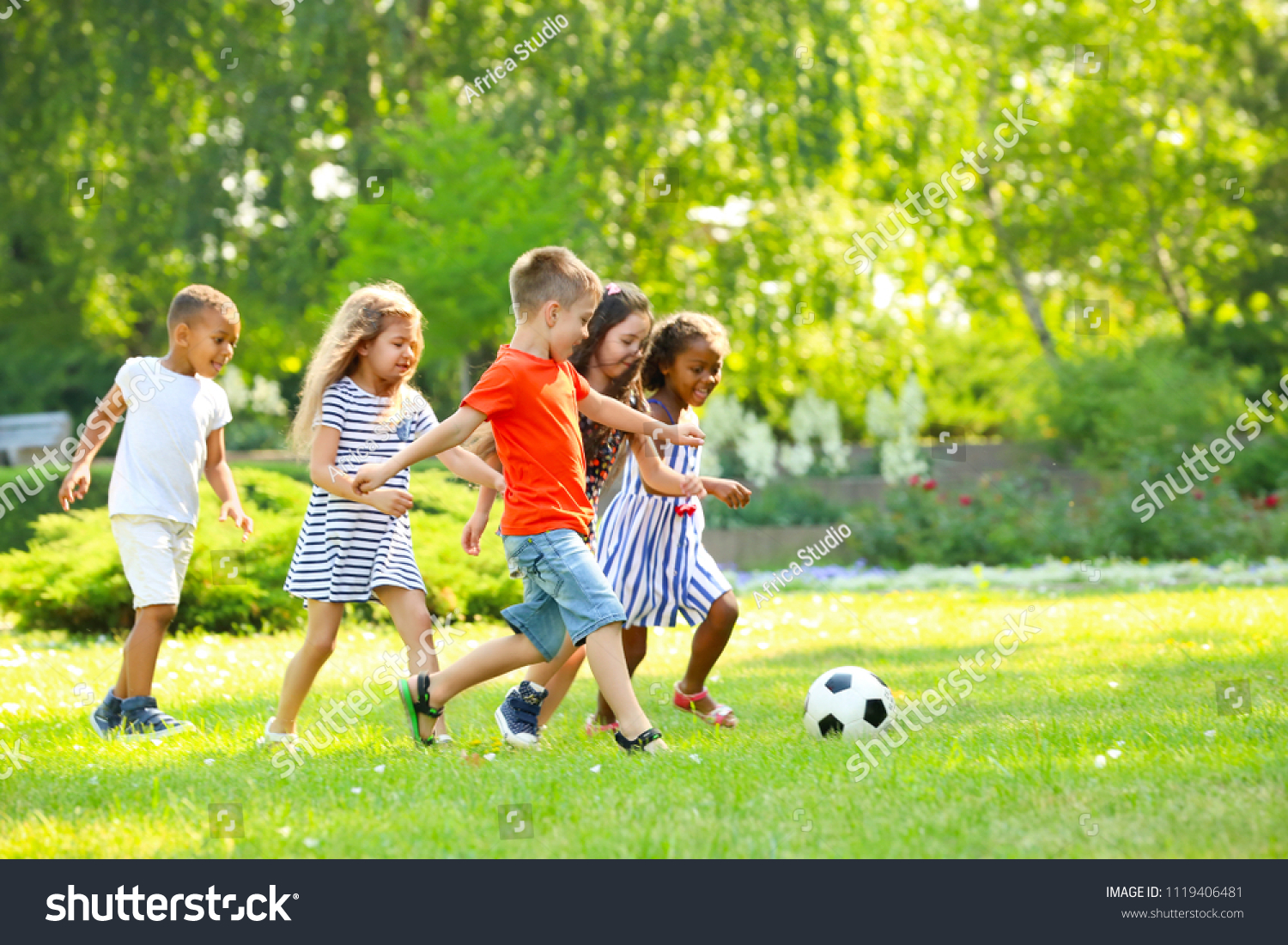 Cute little children playing football outdoors #1119406481