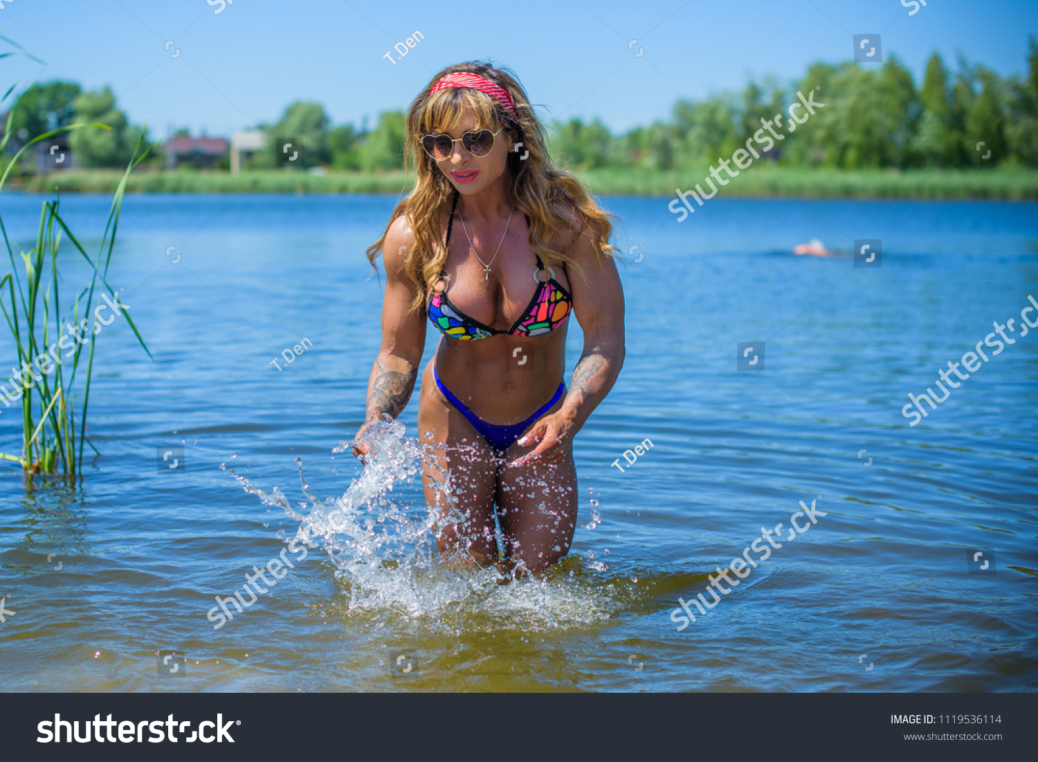 Fitness sport style bodybuilder woman on a nature. Life of mature fit woman. Lady demonstration her body with a tan #1119536114