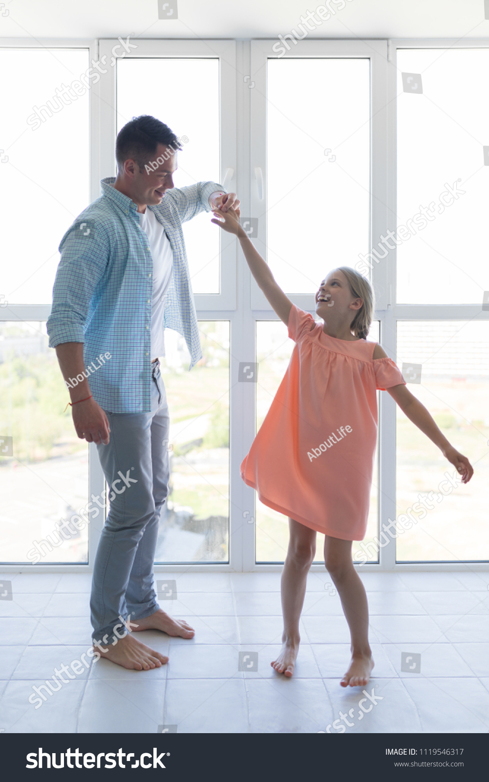 Young father and a little daughter dancing at home #1119546317
