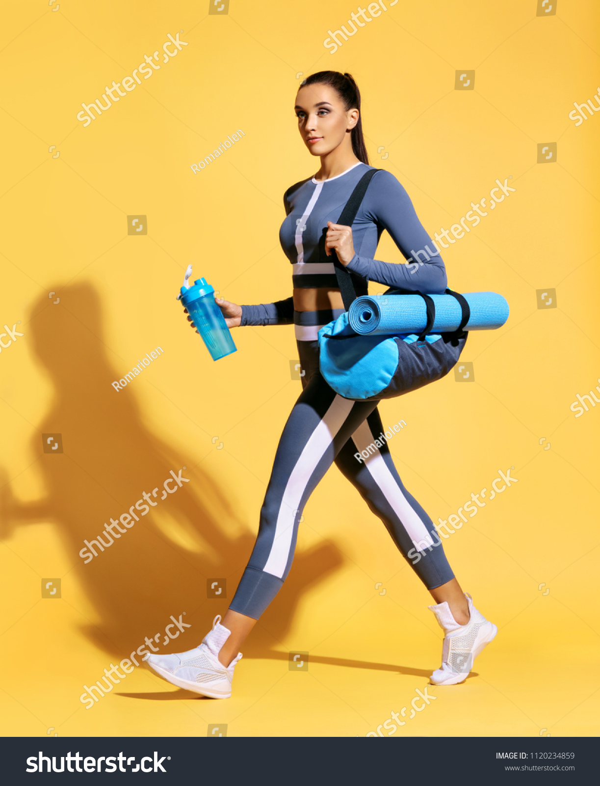 Go to gym! Attractive latin woman in fashionable sportswear on yellow background. Dynamic movement. Side view. Sports and healthy lifestyle #1120234859
