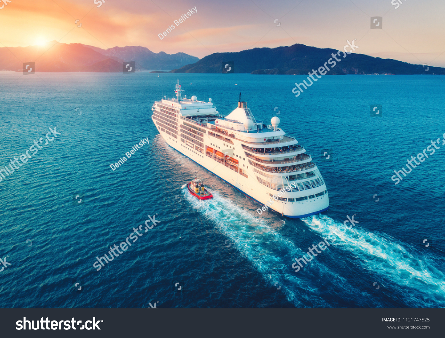 Cruise ship at harbor. Aerial view of beautiful large white ship at sunset. Colorful landscape with boats in marina bay, sea, colorful sky. Top view from drone of yacht. Luxury cruise. Floating liner #1121747525