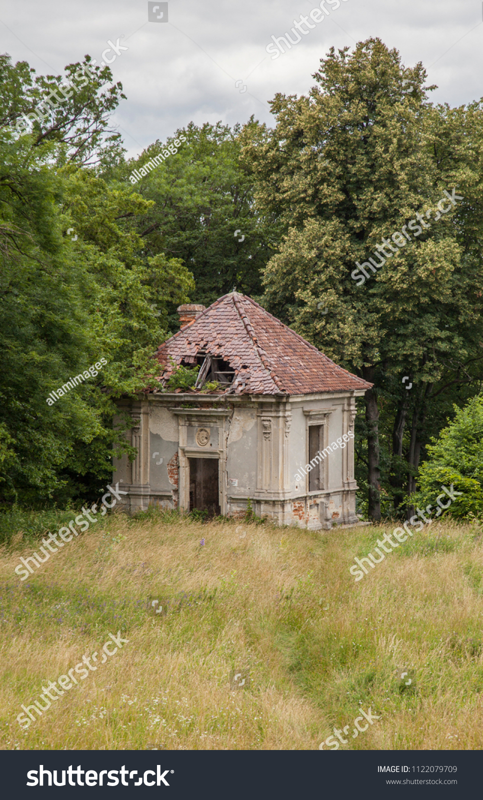 Very old historic building with wonderful architecture Old stones in the nature of the stone building is a wonderful design pastel grey color shades of green nature. #1122079709
