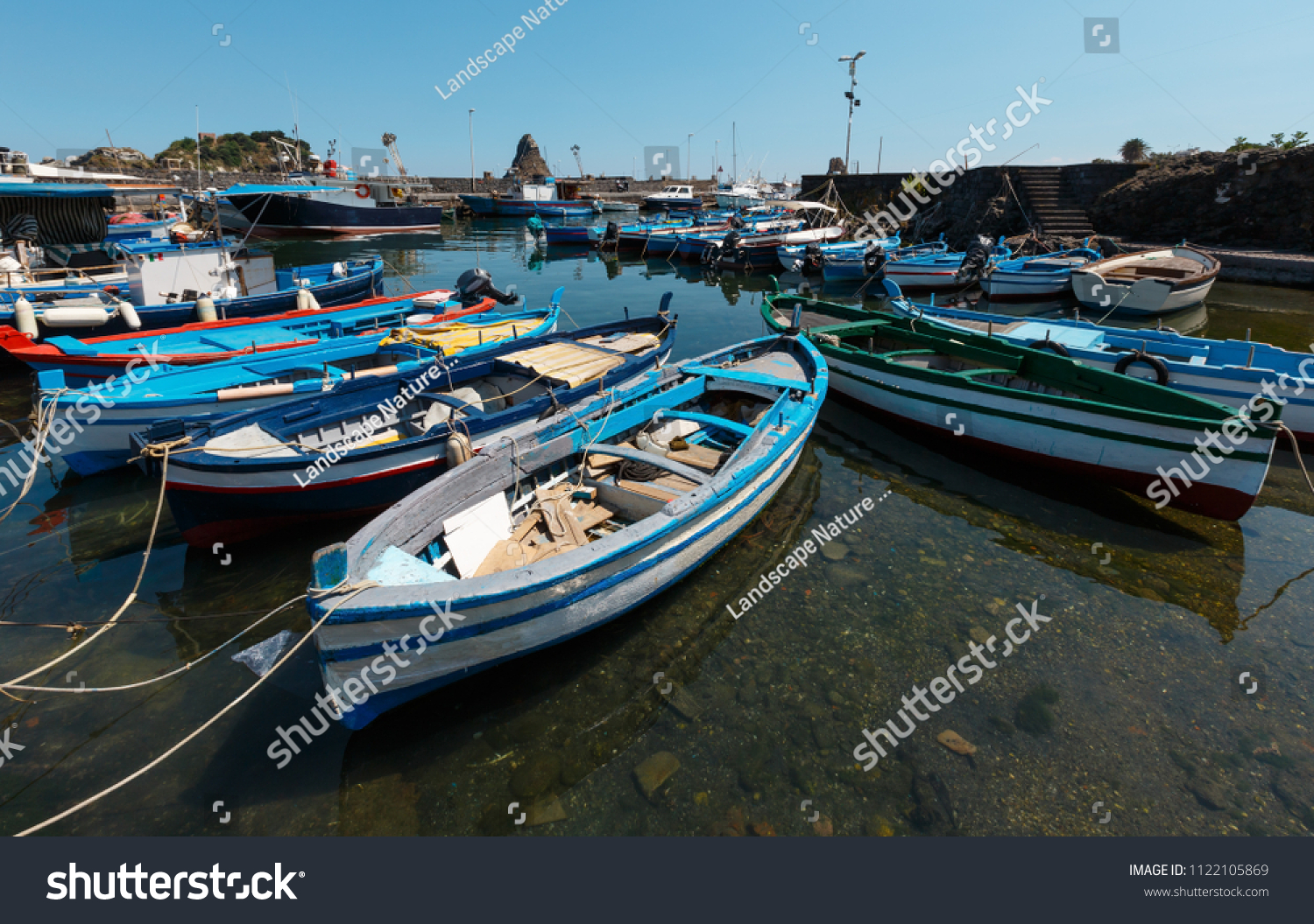 Aci Trezza Marina dei Ciclopi boats harbor. Lachea Island on Cyclopean Coast and the Islands of the Cyclops behind (Italy, Sicily,10 km north of Catania). Known as Isoles Dei Ciclopi. #1122105869