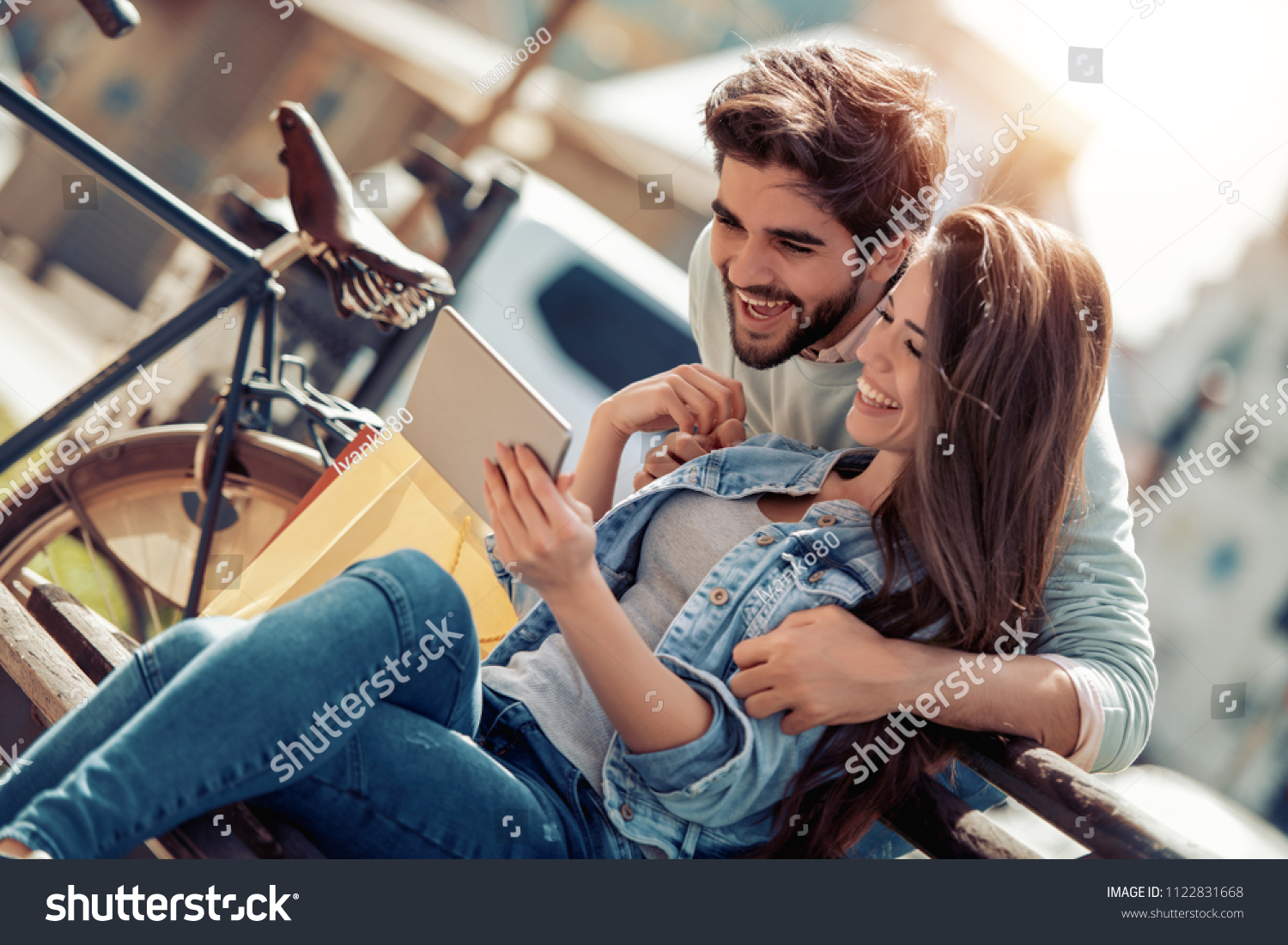 Happy young couple having fun outdoors,using tablet. #1122831668