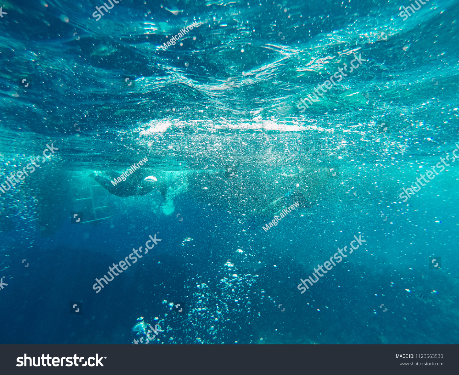 Bubbles in turquoise blue water in red sea. Sunny day #1123563530