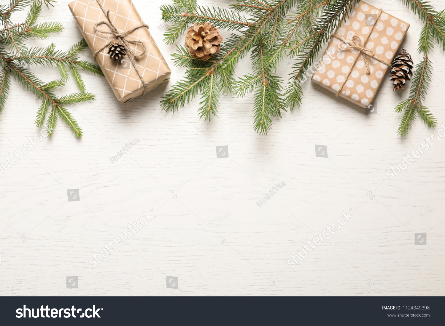 Flat lay composition with Christmas gifts and fir branches on light background #1124349398