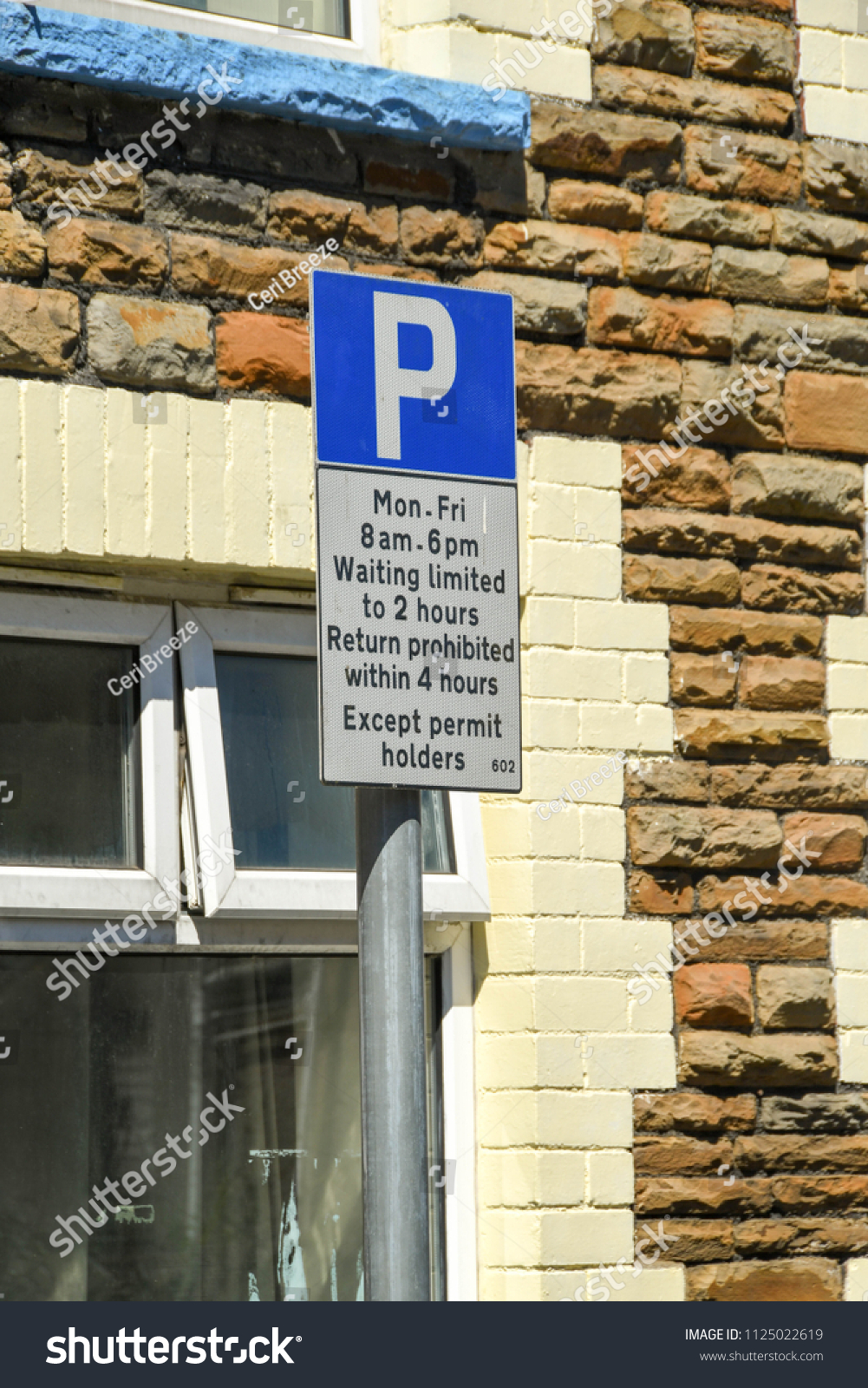 TREFOREST, PONTYPRIDD, WALES - JUNE 2018: Close up view of a sign in a residential street with information on parking restrictions for non-permit holders #1125022619