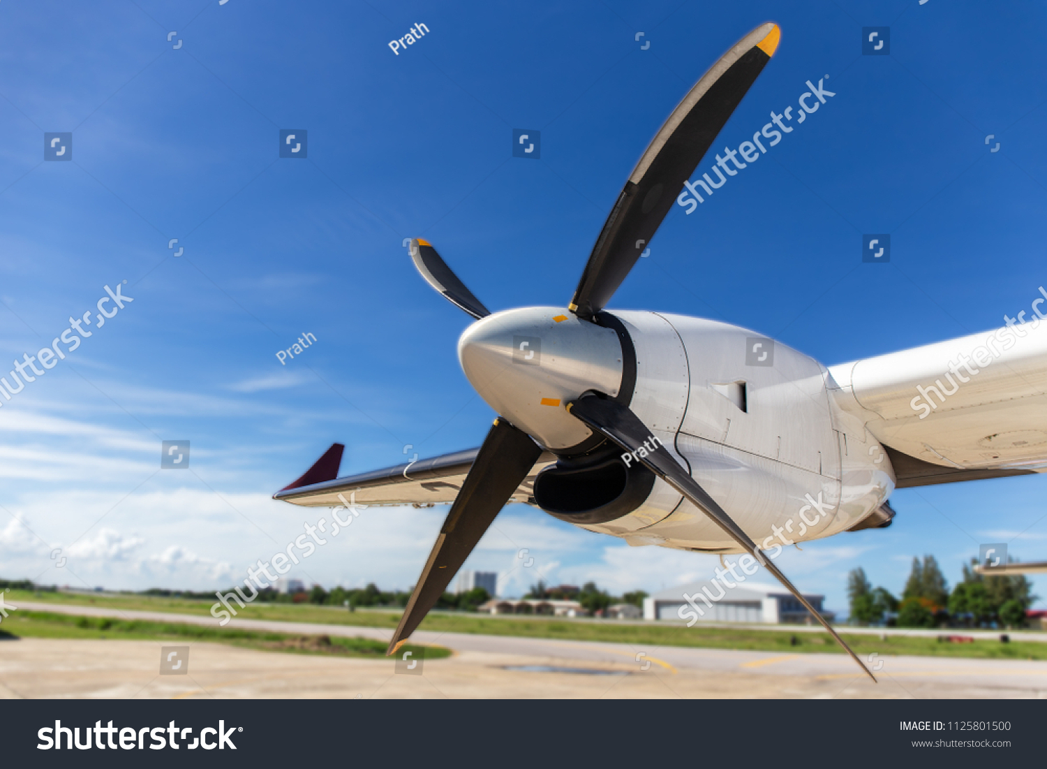 aircraft propeller blade and turboprop engines with airfield, blue sky background and copy space #1125801500