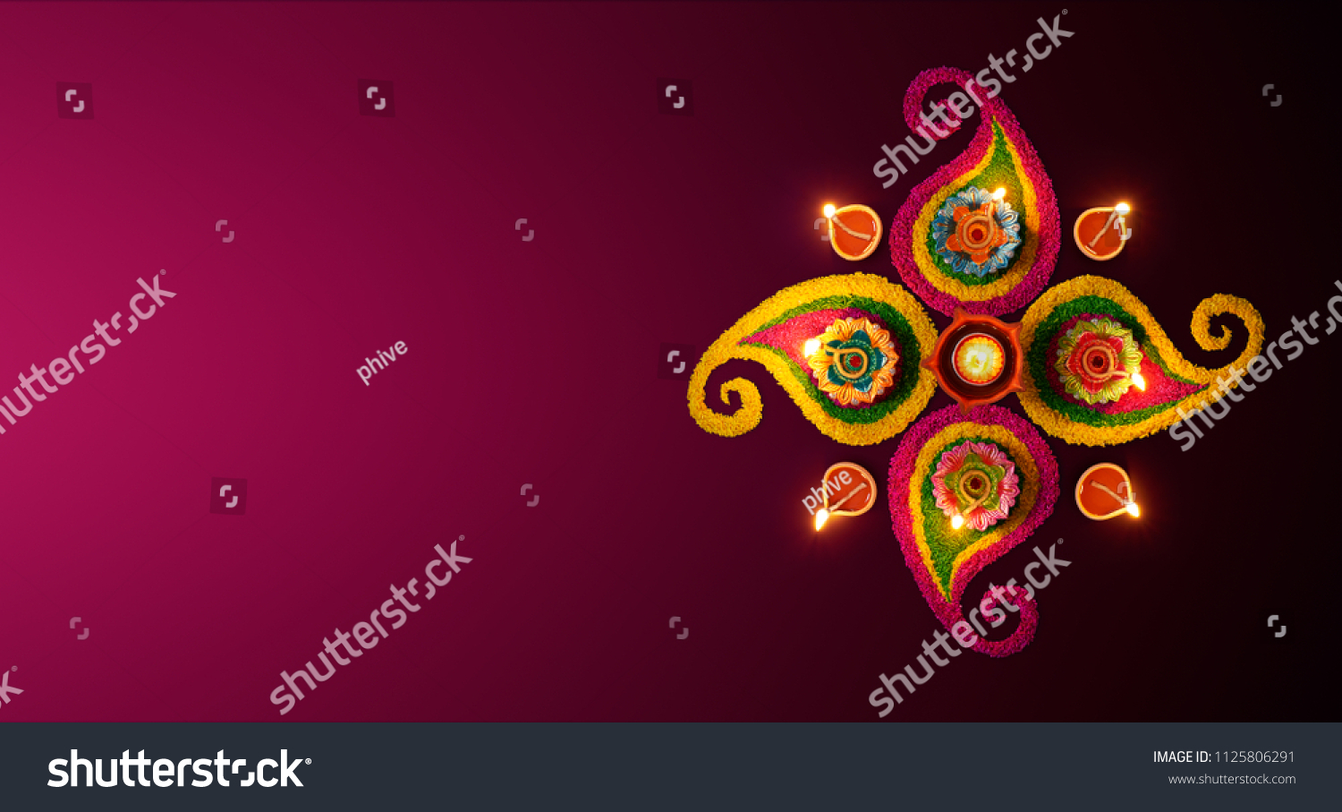 Diwali celebration - Diya oil lamps lit on colorful rangoli #1125806291