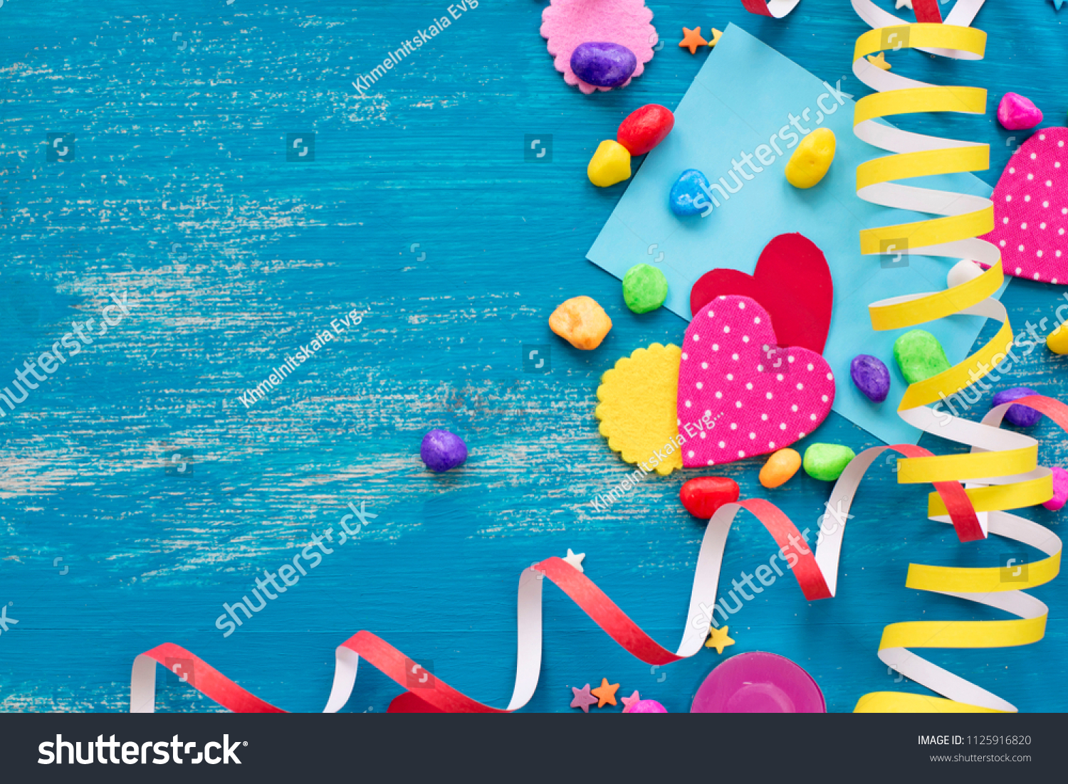 Festive confetti background heart candy color saturated. Wood old blue background with copy space flat lay #1125916820