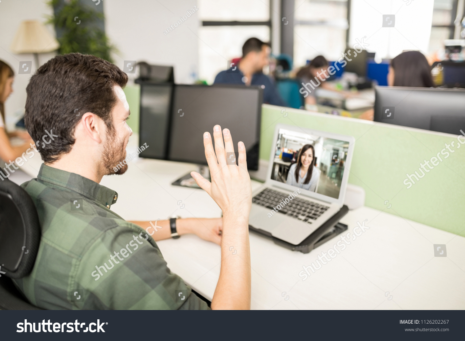 Young hispanic man working at his desk and making video call with his laptop #1126202267