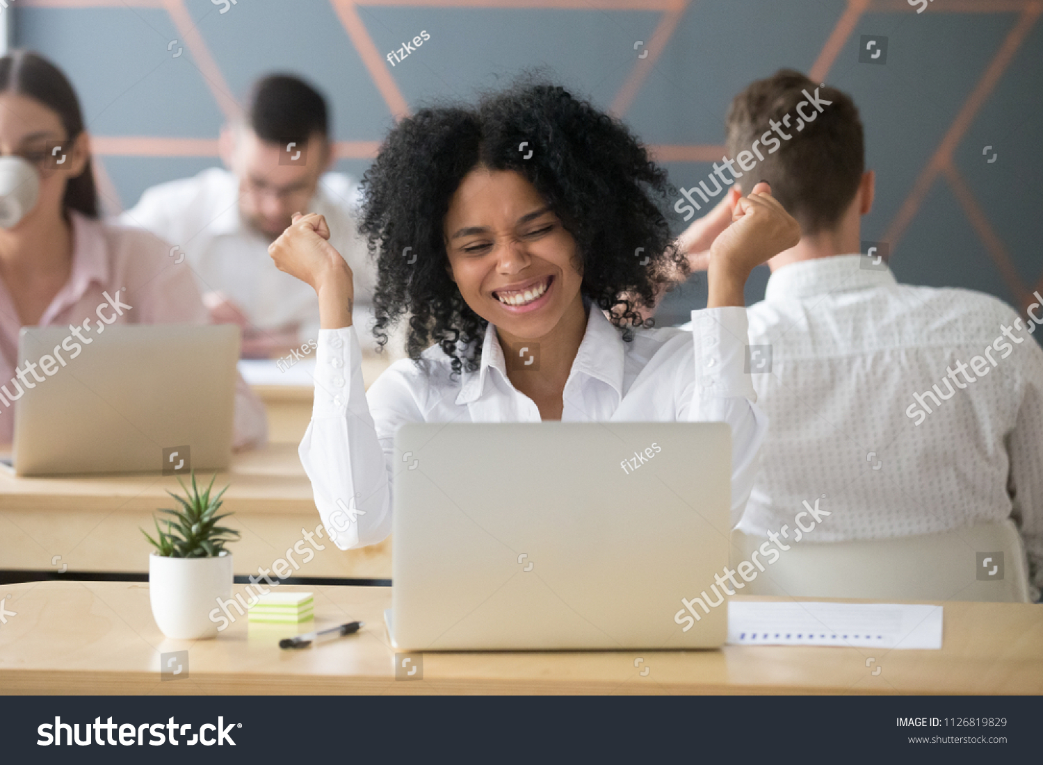 Excited African American worker screaming with happiness winning online lottery, happy black employee getting promotion letter at laptop, relocating to dream position. Rewarding concept #1126819829
