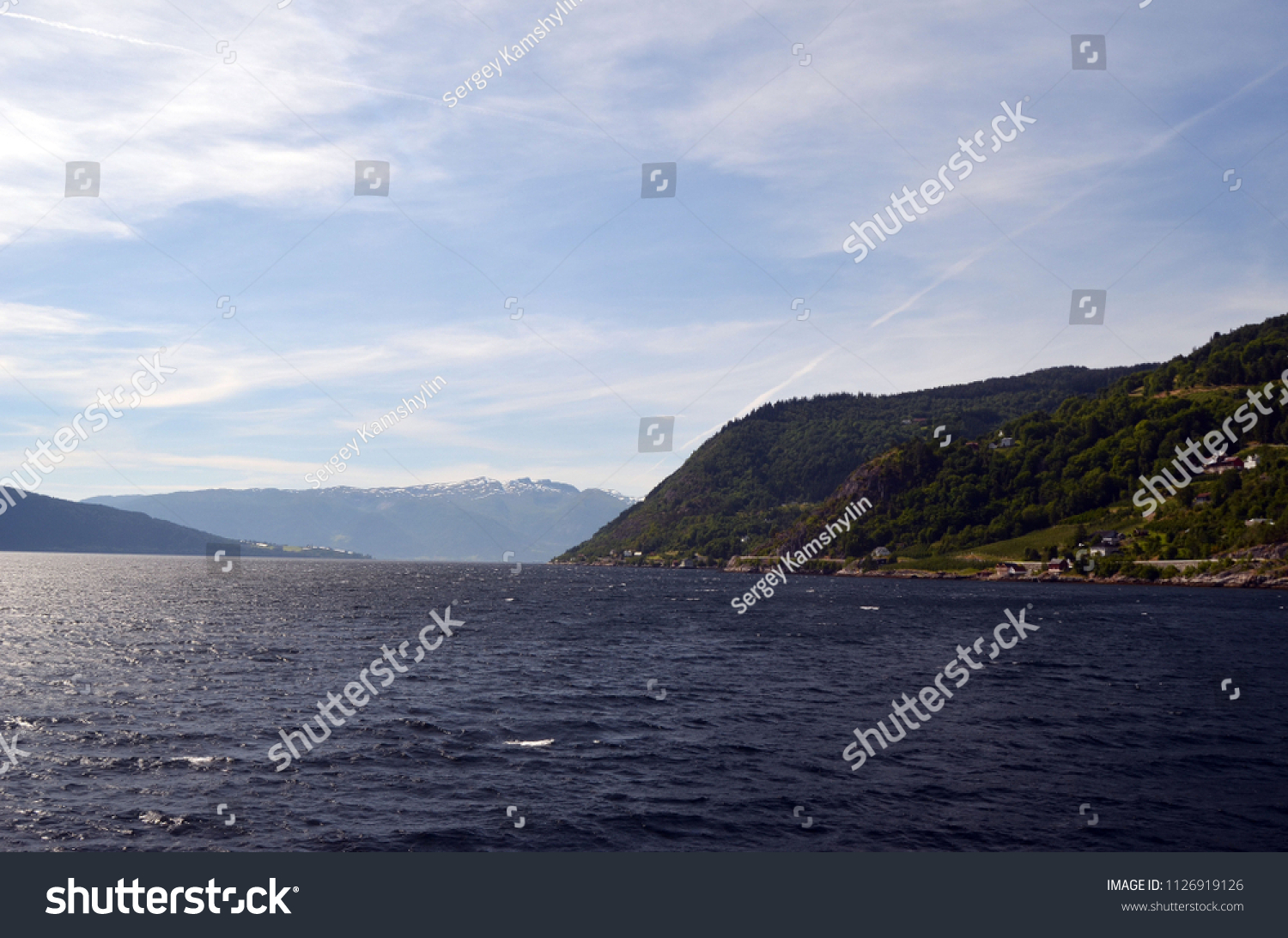 Mountains and fjord in Norway. Clouds and blue sky. Beautiful stunning views of mountains, water, sky, clouds and sun. Norwegian nature. Sognefjord #1126919126