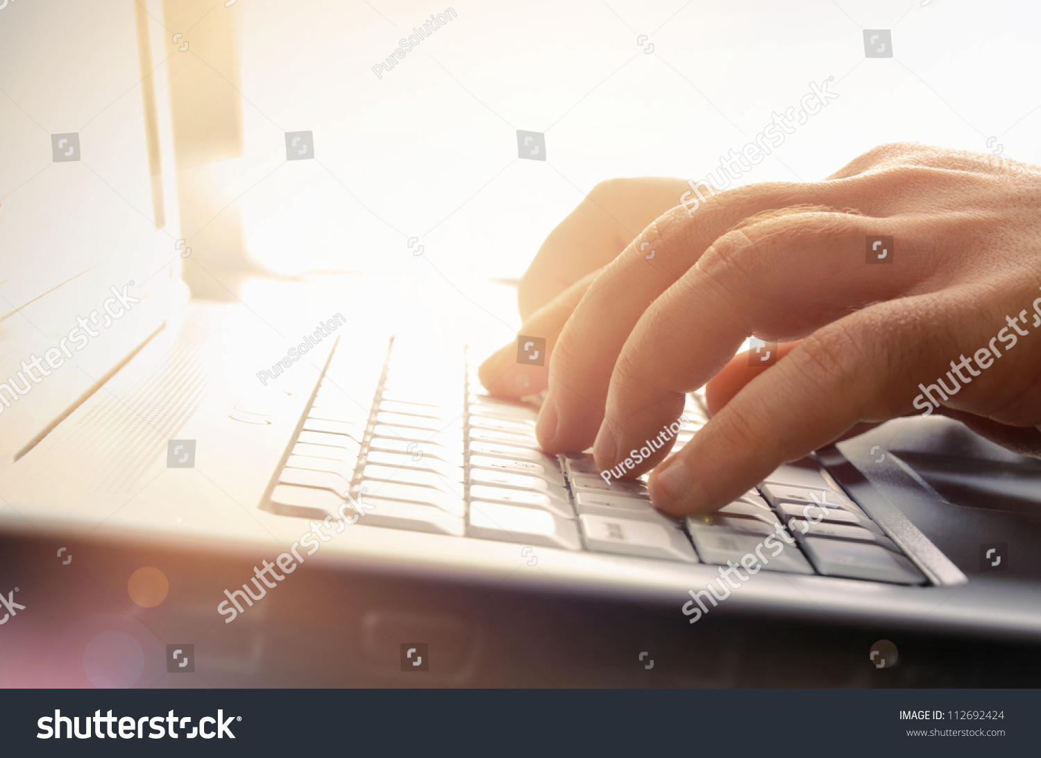 Man's hands typing on laptop keyboard #112692424