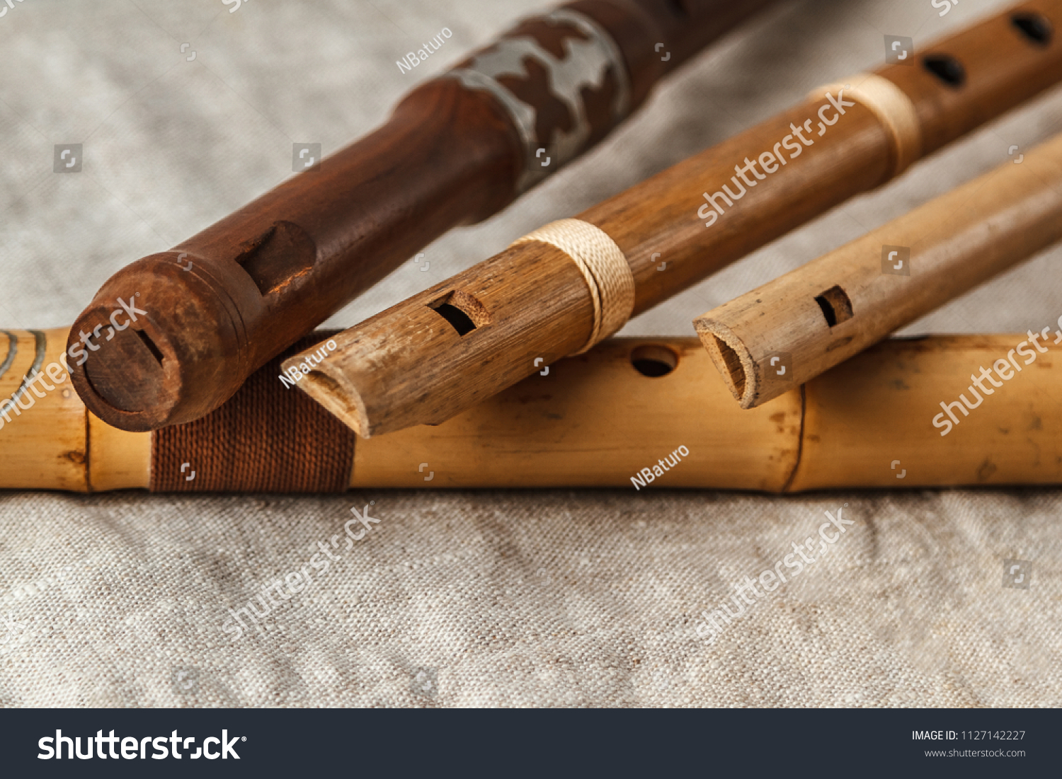 Wooden flute on grey linen tablecloth #1127142227