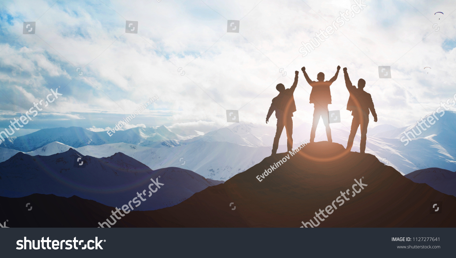 Silhouette of the team on the mountain. Leadership Concept #1127277641