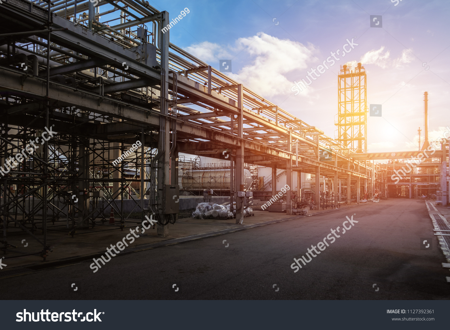 Pipeline and pipe rack of petroleum industrial plant with sunset sky background #1127392361