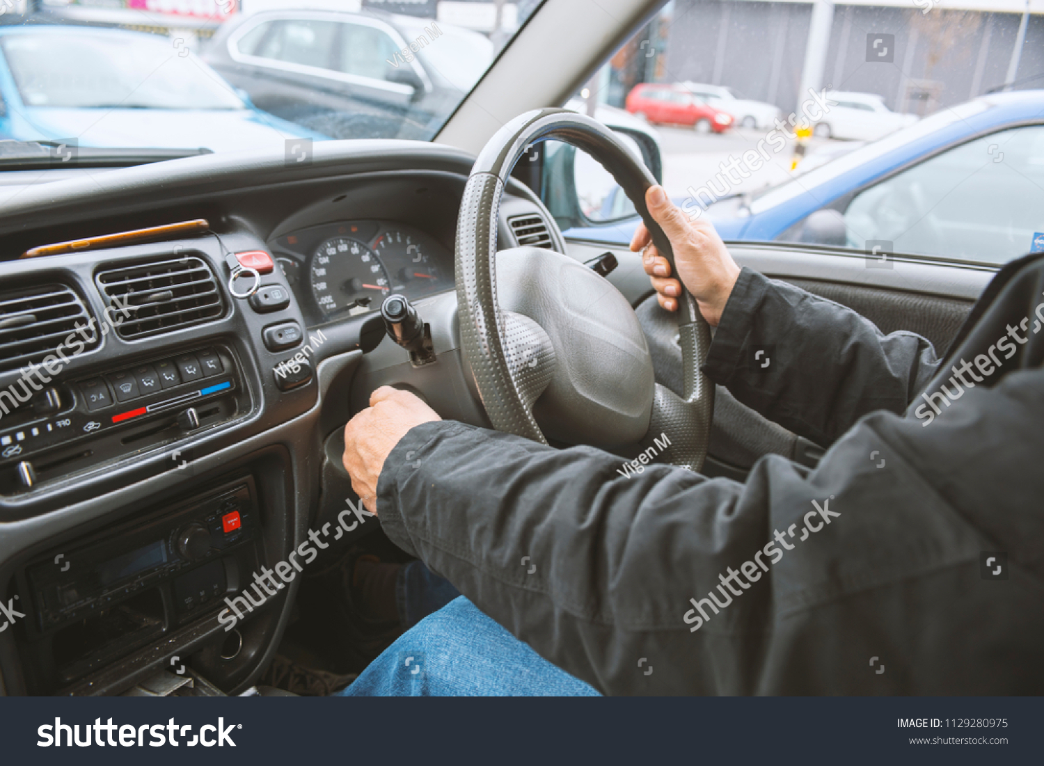 Right hand drive car. Man hand holding steering wheel #1129280975
