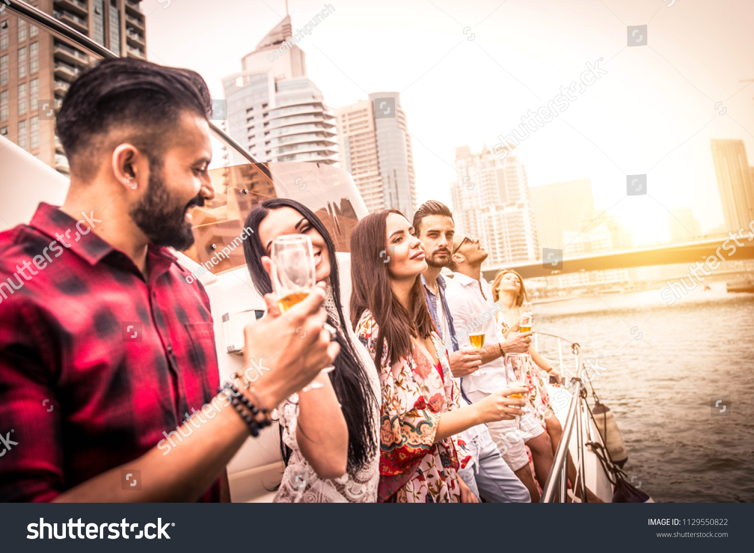 Group of friends making party on a yacht in Dubai - Happy people having a fancy party on a luxury boat #1129550822