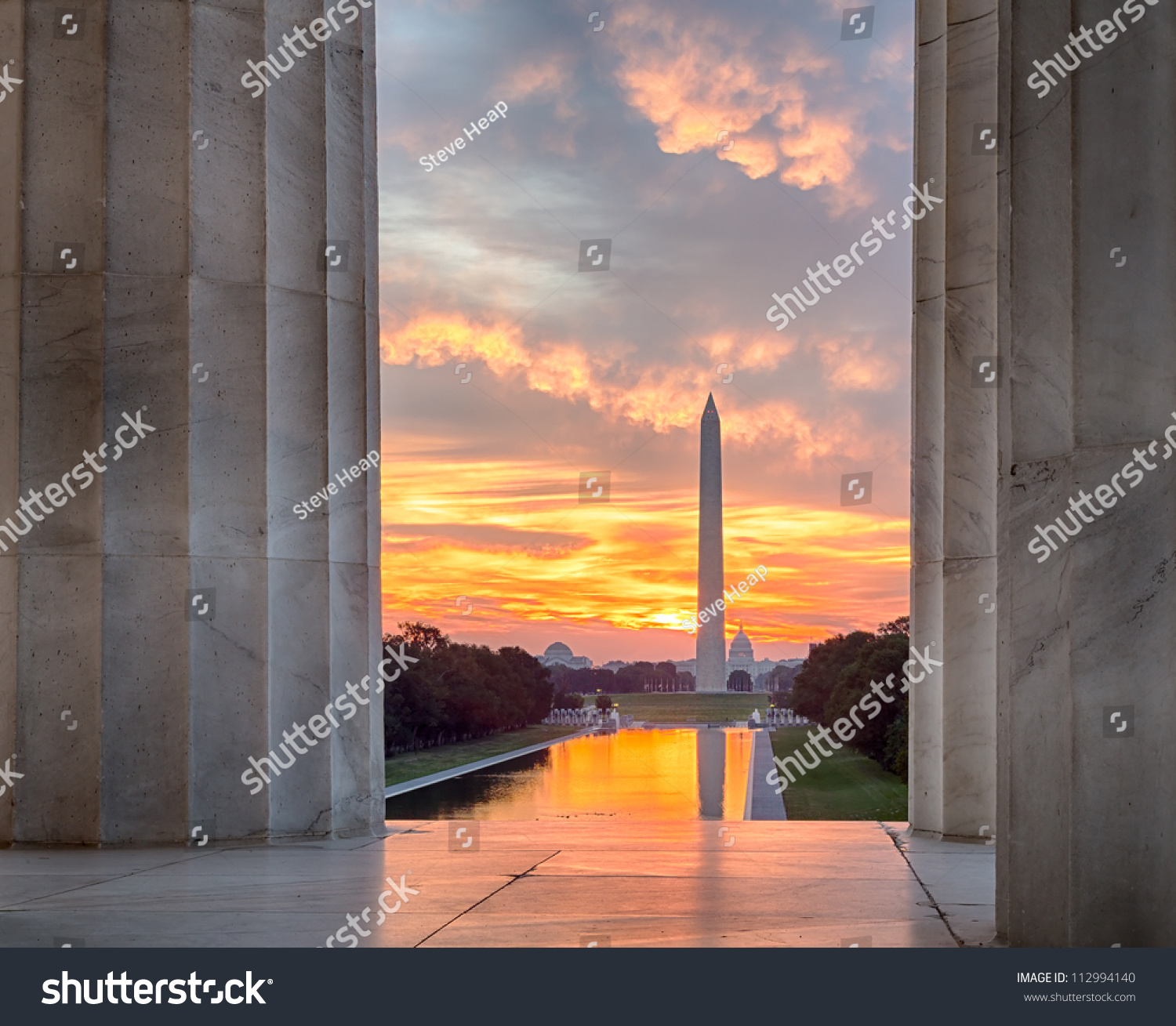 Bright red and orange sunrise at dawn reflects Washington Monument in new reflecting pool by Lincoln Memorial #112994140