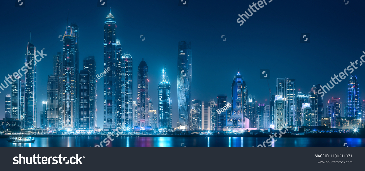 Modern buildings of Dubai Marina bay with lights at night on background, view from Palm Jumeirah, UAE #1130211071