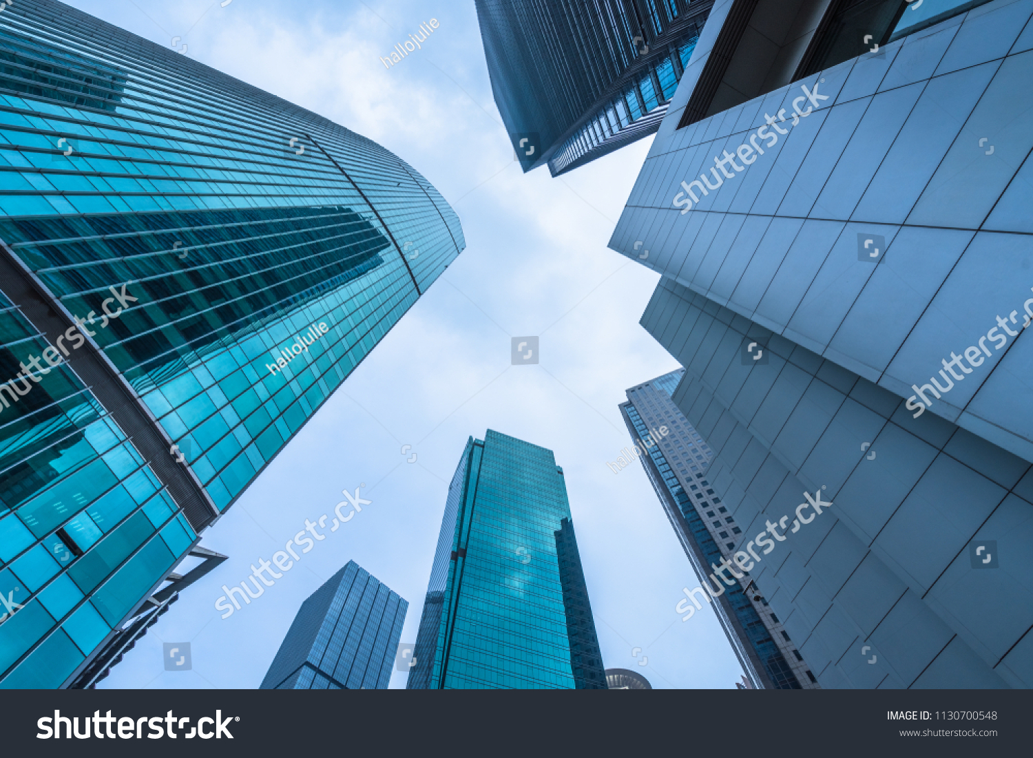 Bottom view of modern skyscrapers in business district against blue sky
 #1130700548